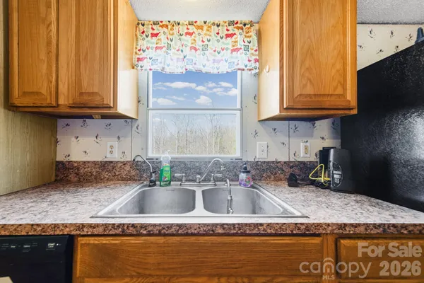 a kitchen with granite countertop a sink a stove and cabinets