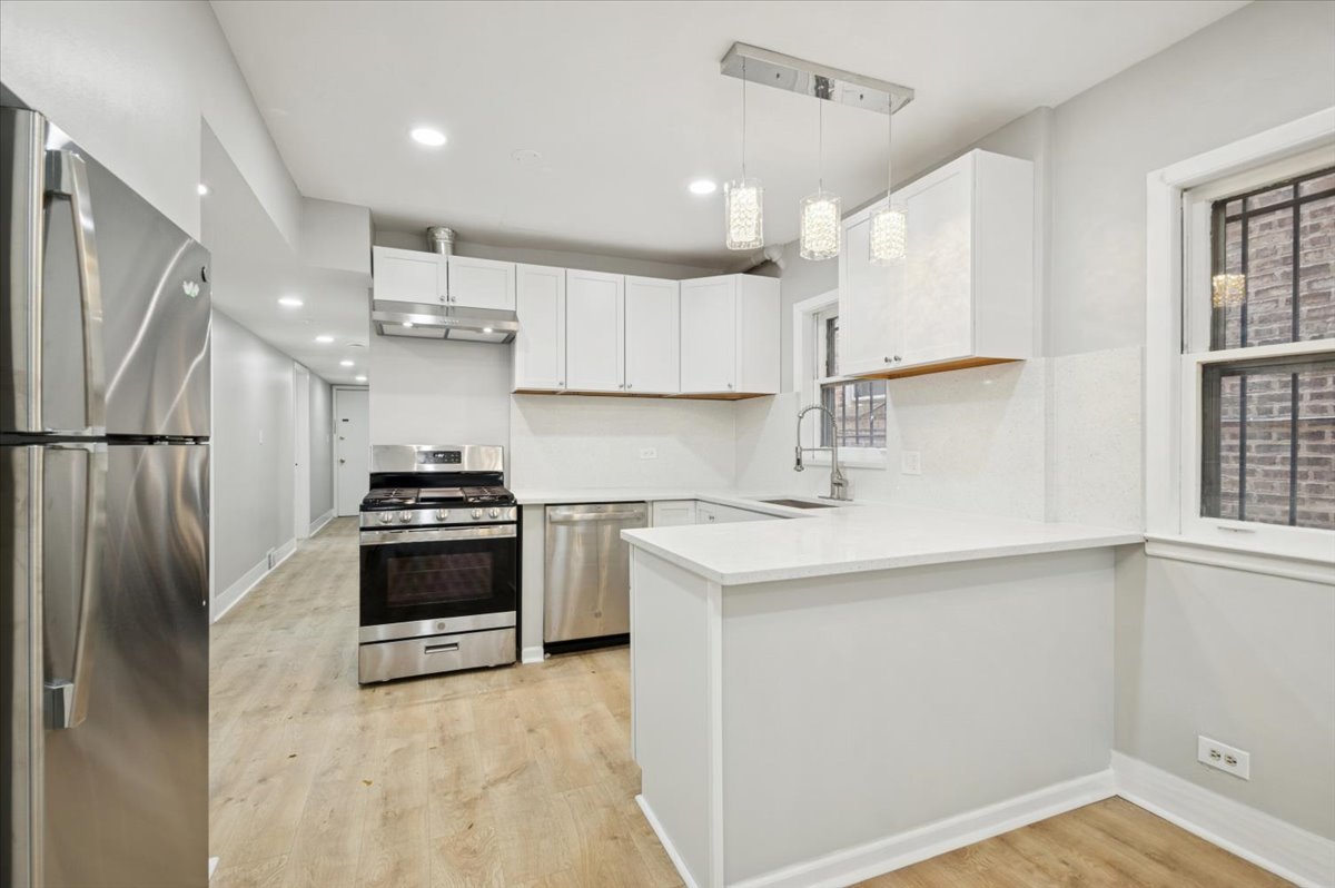 2623 West Arthur Avenue, Unit 1 Chicago, IL 60645 - Photo 5 of 11 a kitchen with stainless steel appliances a refrigerator sink and stove