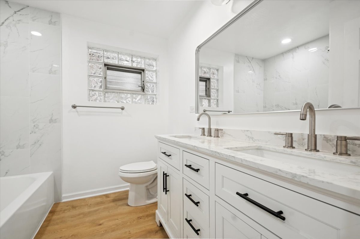 2623 West Arthur Avenue, Unit 1 Chicago, IL 60645 - Photo 8 of 11 a bathroom with a granite countertop sink mirror vanity and toilet