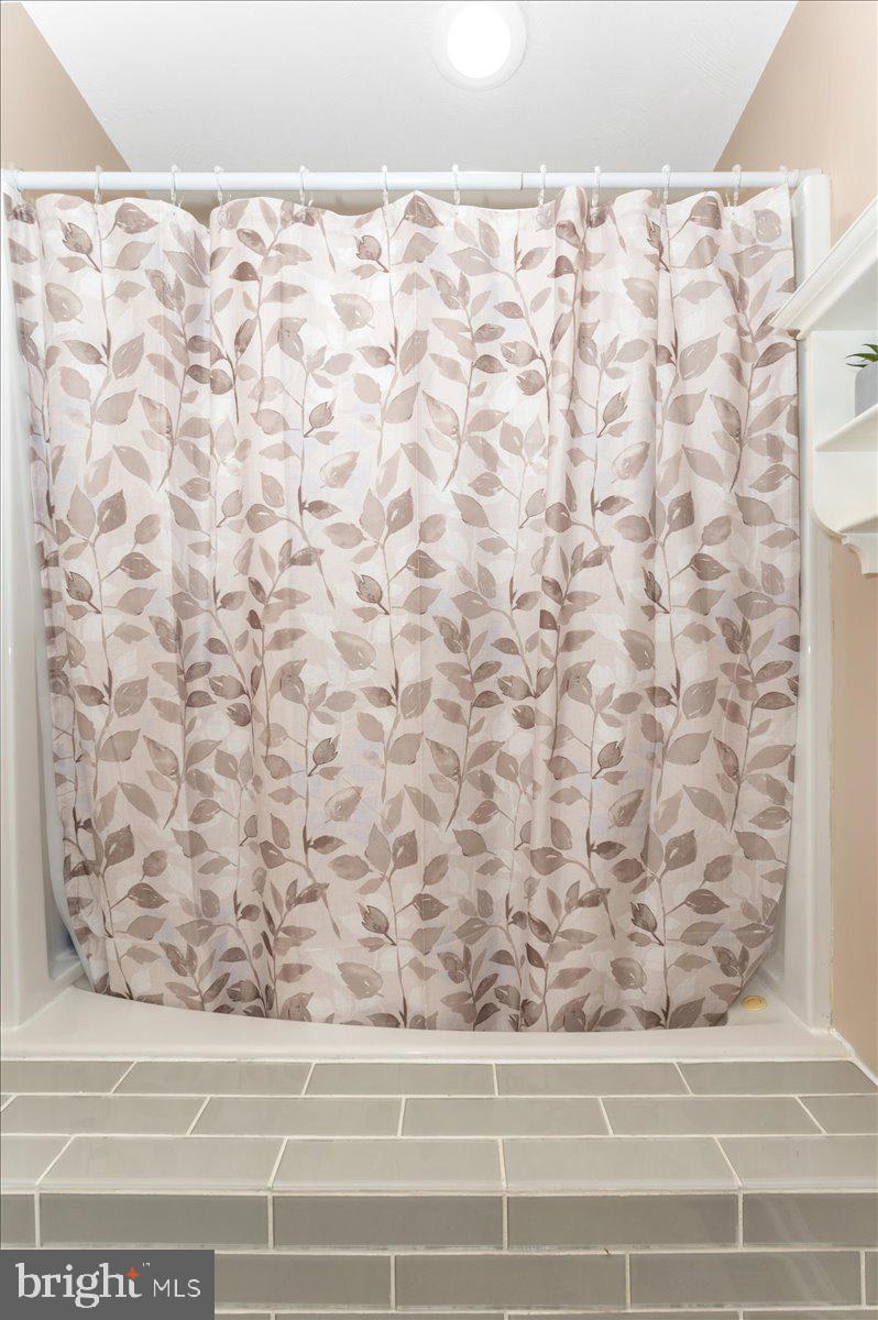 8109 Beverly Road Severn, MD 21144 - Photo 25 of 43 a small bathroom with a shower curtain