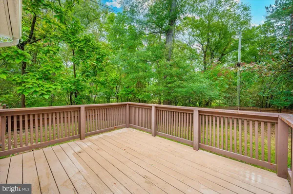a balcony with wooden floor and trees in the background