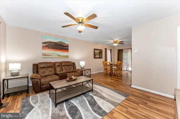 a living room with furniture and a table with wooden floor