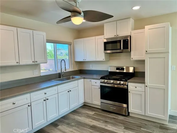 a kitchen with stainless steel appliances granite countertop a stove a sink and a microwave