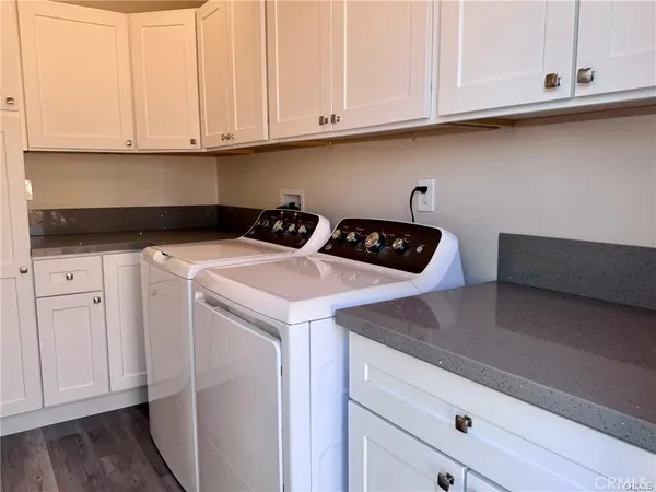 a kitchen with white cabinets and sink