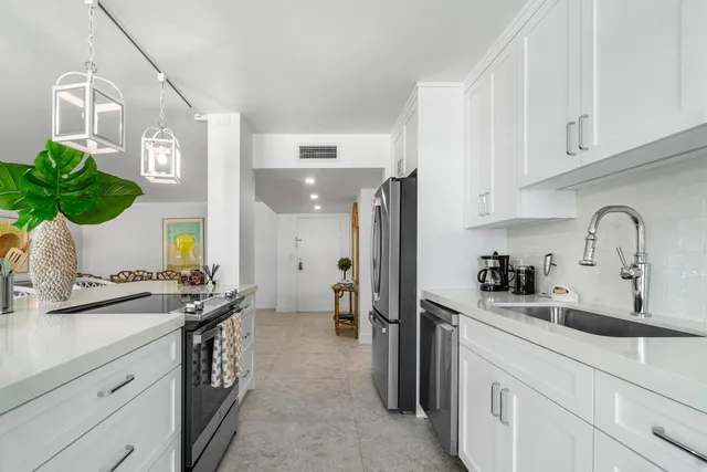 a kitchen with a sink refrigerator and cabinets