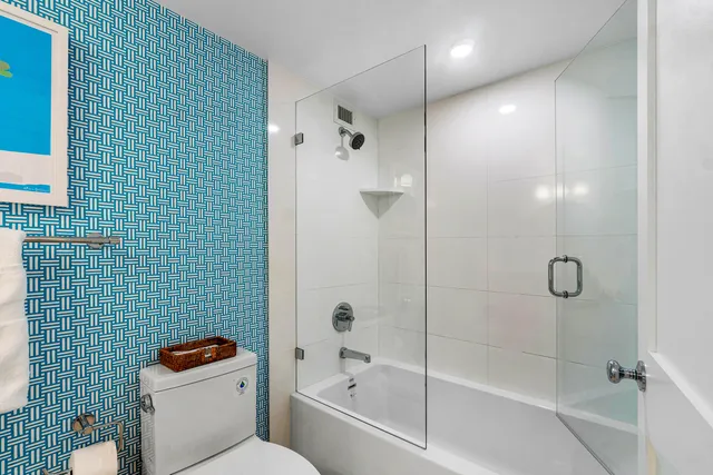 a bathroom with a shower a toilet and a sink