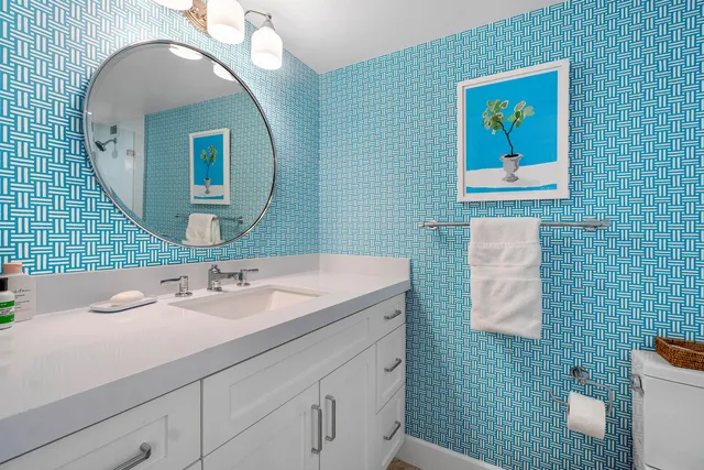 a bathroom with a sink mirror and toilet