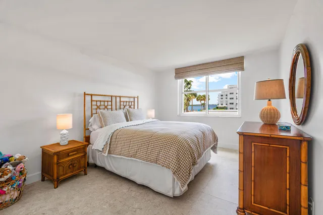 a bedroom with a bed a window and dresser