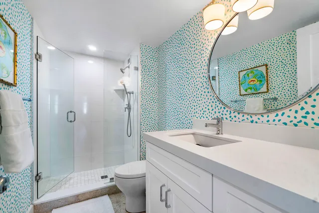 a bathroom with a sink a toilet and shower