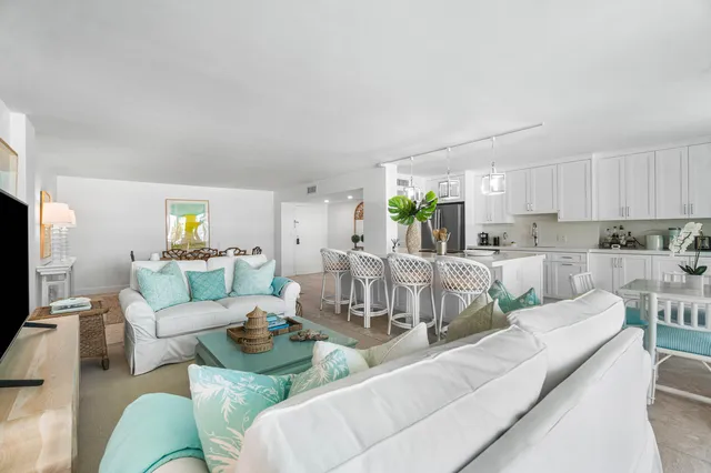 a living room with furniture white walls and a view of kitchen