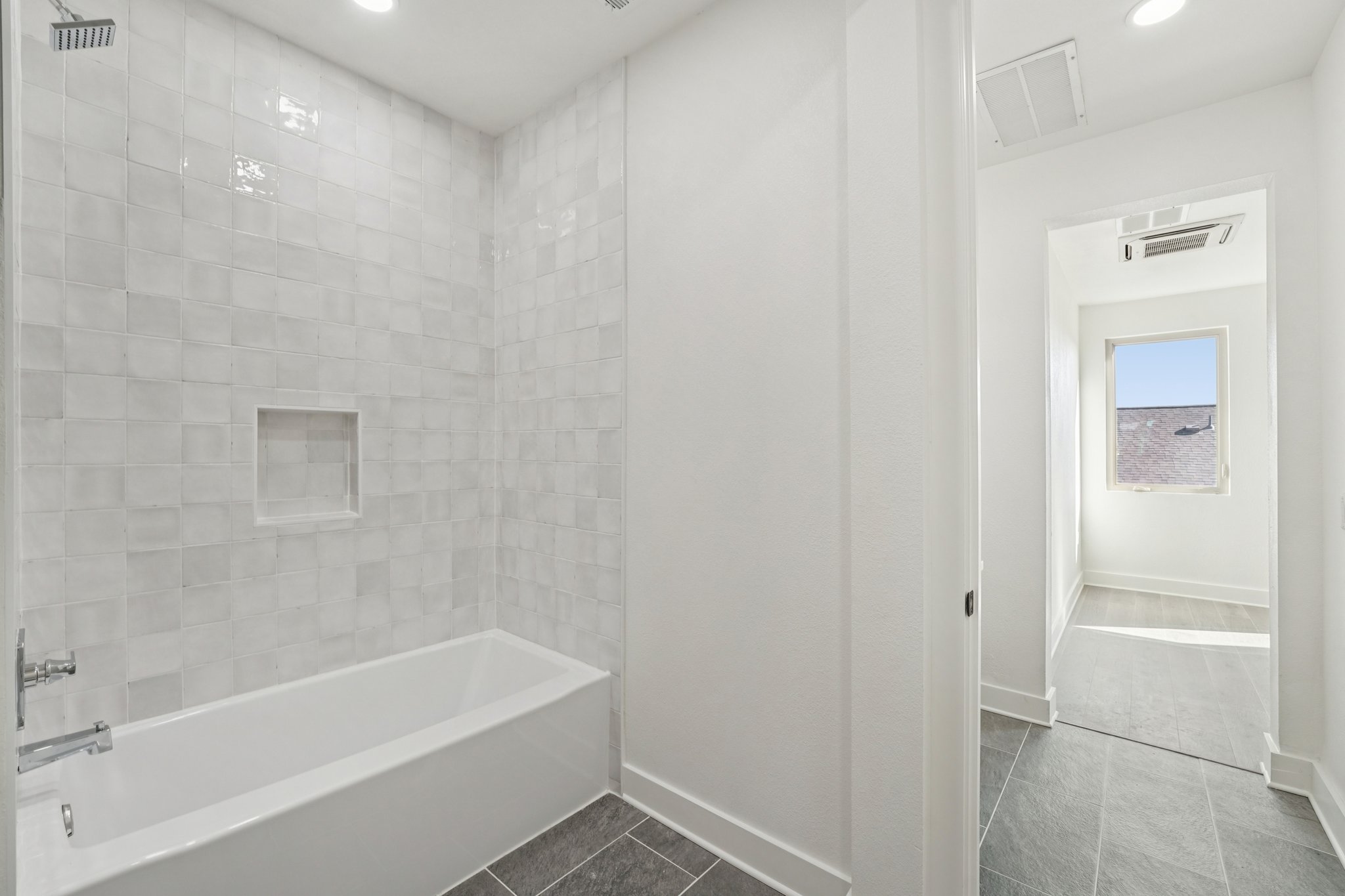 2811 Zach Scott Street Austin, TX 78723 - Photo 31 of 37 Bathroom featuring bathing tub / shower combination, dark tile patterned flooring, and recessed lighting
