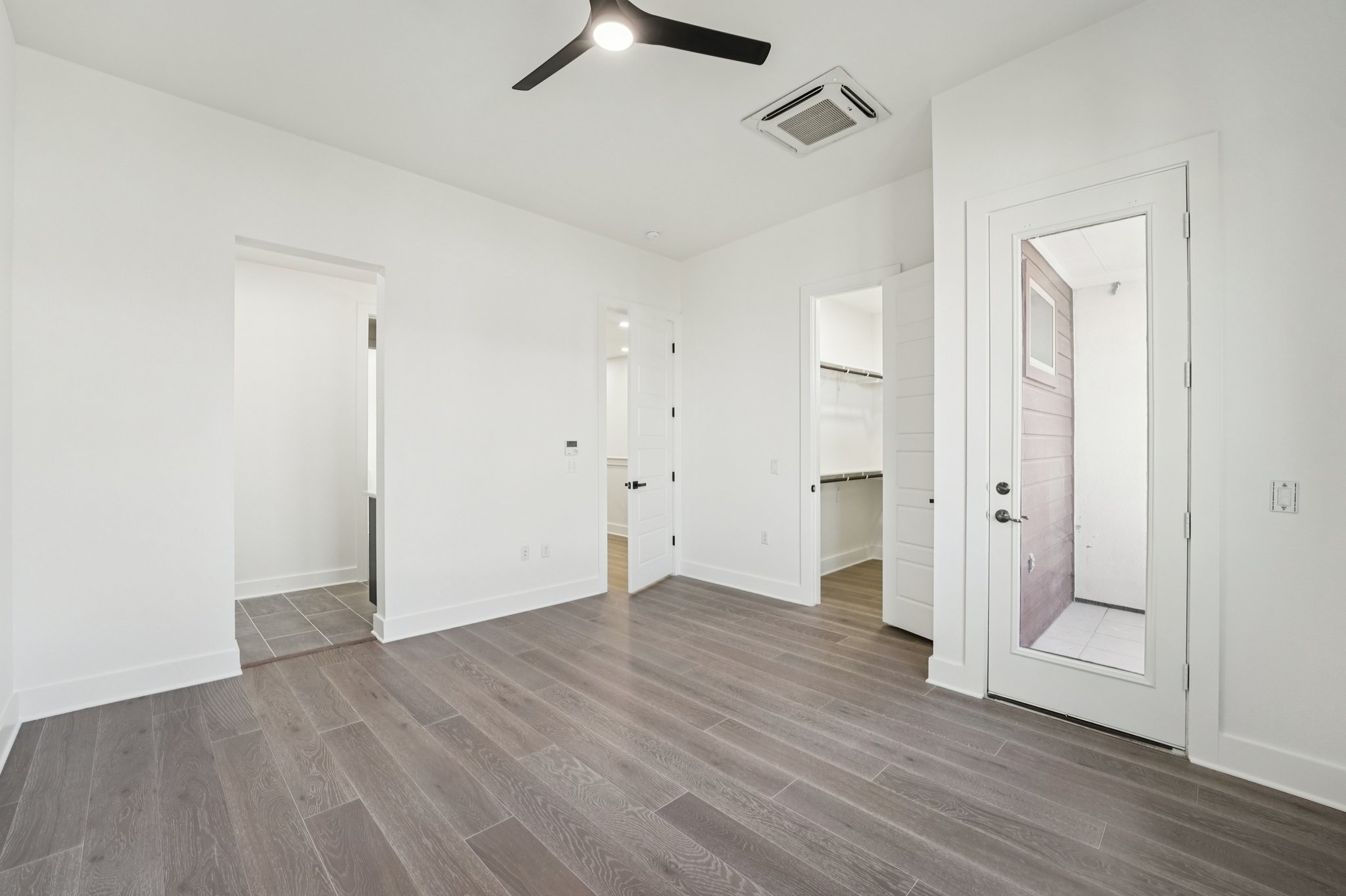 2811 Zach Scott Street Austin, TX 78723 - Photo 34 of 37 Unfurnished bedroom featuring a spacious closet, wood finished floors, ceiling fan, and connected bathroom