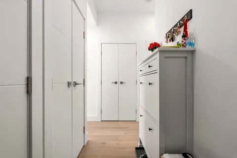 a view of a hallway with wooden floor and closet