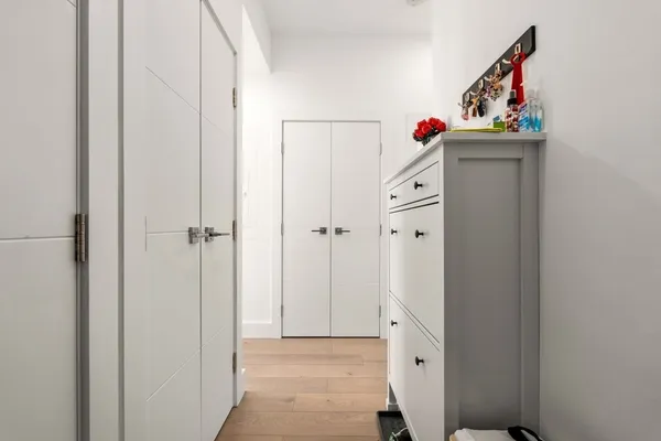 a view of a hallway with wooden floor and closet