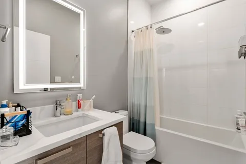 a bathroom with a sink toilet vanity and shower