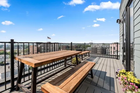 a roof deck with wooden floor and fence