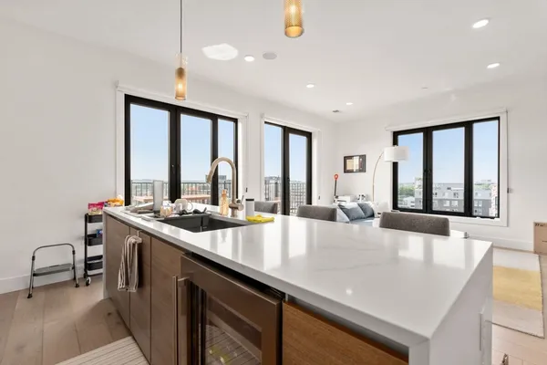 a large kitchen with kitchen island a large window in it
