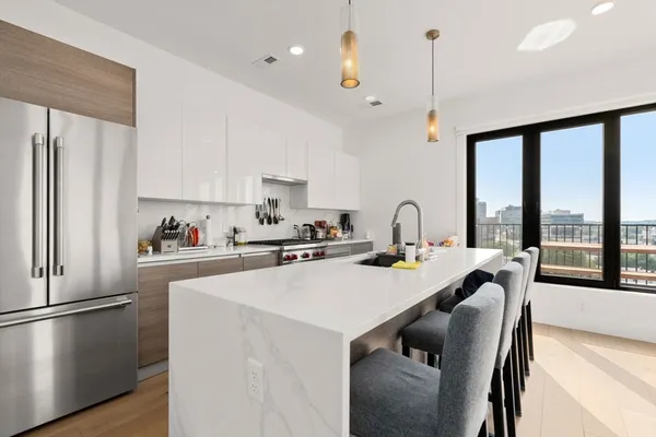 a kitchen with stainless steel appliances granite countertop a sink a stove and a refrigerator