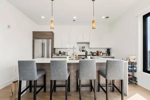 a kitchen with a dining table chairs and white cabinets