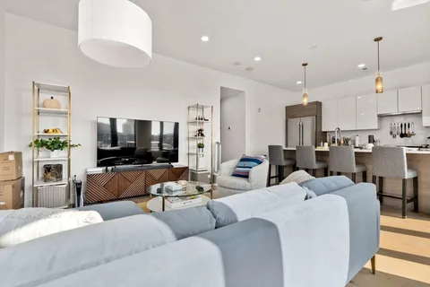a living room with furniture kitchen view and a flat screen tv