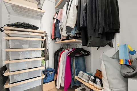 a view of walk in closet with clothes and shoes