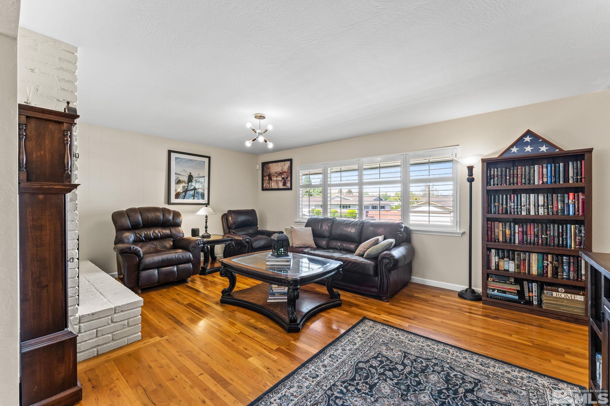 1070 Pineridge Drive Reno, NV 89509 - Photo 4 of 24 a living room with furniture a rug and a bookshelf