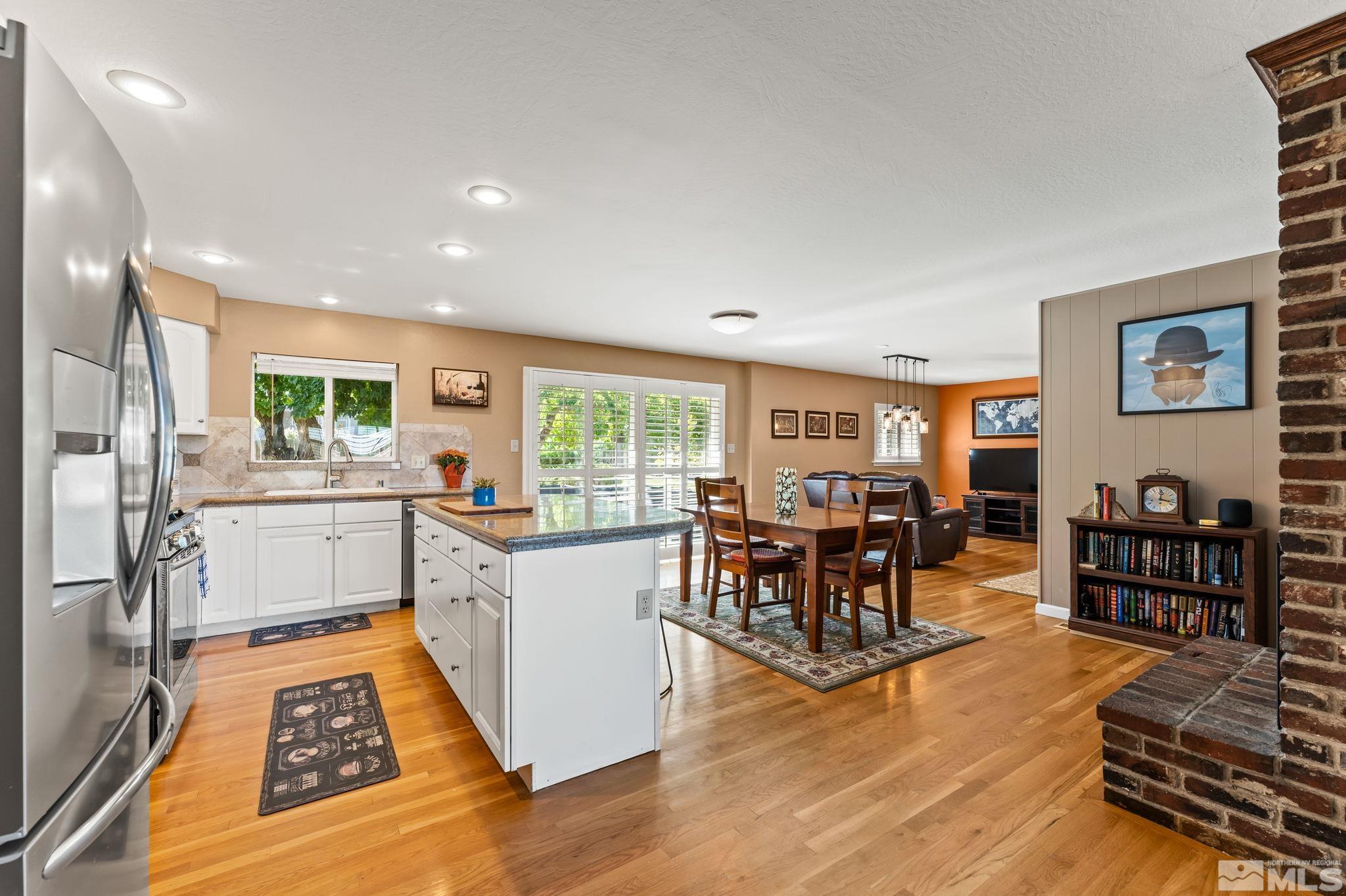 1070 Pineridge Drive Reno, NV 89509 - Photo 6 of 24 a open kitchen with stainless steel appliances granite countertop a stove and a dining table with wooden floor