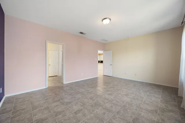 a spacious bathroom with a granite countertop sink a toilet a mirror and a bathtub