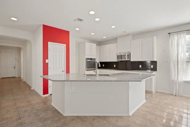 a kitchen with stainless steel appliances granite countertop a stove and a refrigerator