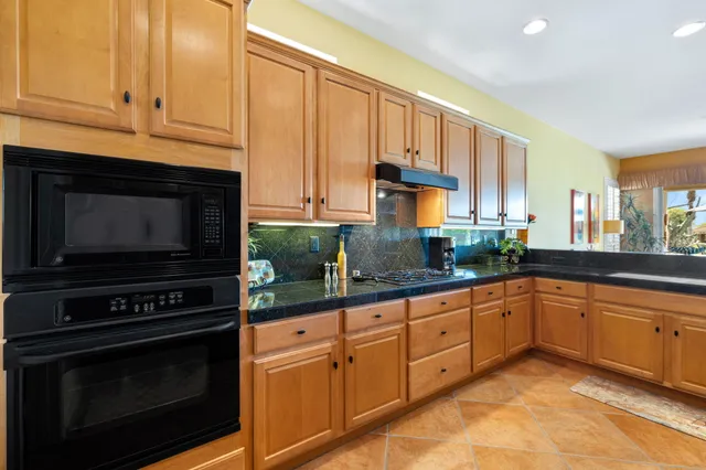 a kitchen with granite countertop cabinets and steel stainless steel appliances