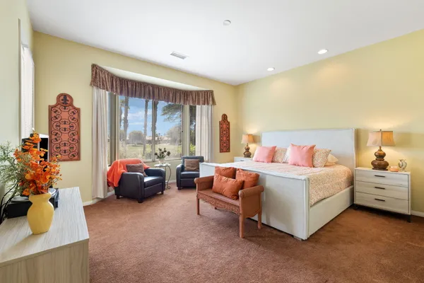 a spacious bedroom with a bed and large windows