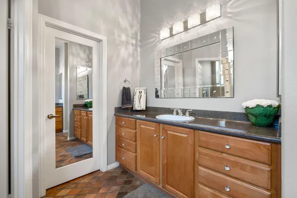 a bathroom with a granite countertop sink and a mirror