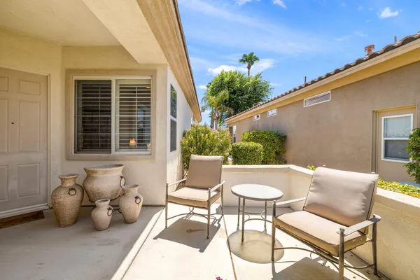 a view of a patio with couple of chairs and a potted plant