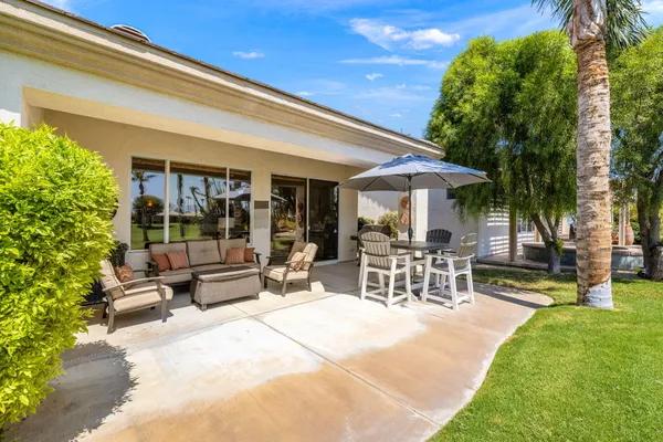 a view of a patio with a table and chairs under an umbrella