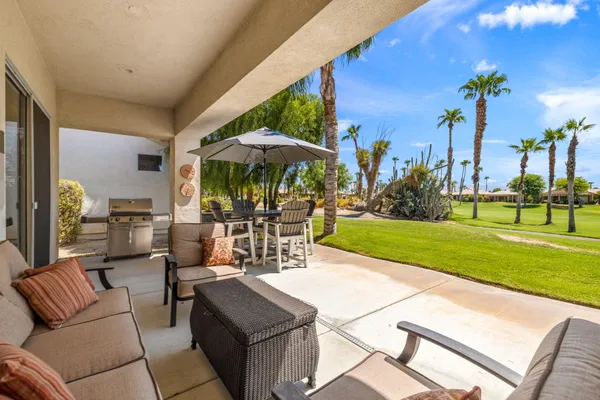 a view of a patio with a table and chairs under an umbrella
