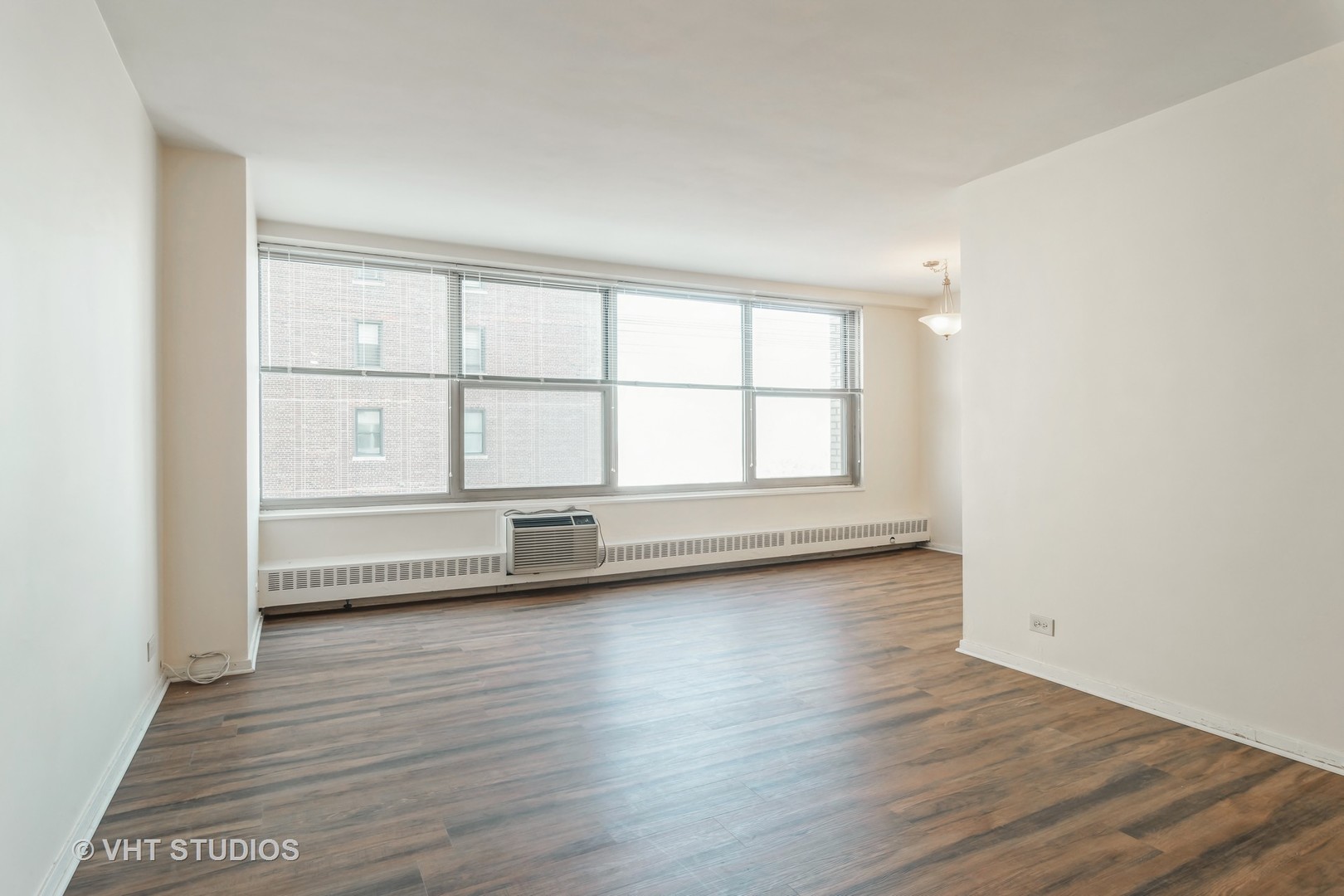3900 North Lake Shore Drive, Unit 9J Chicago, IL 60613 - Photo 3 of 18 an empty room with wooden floor and windows