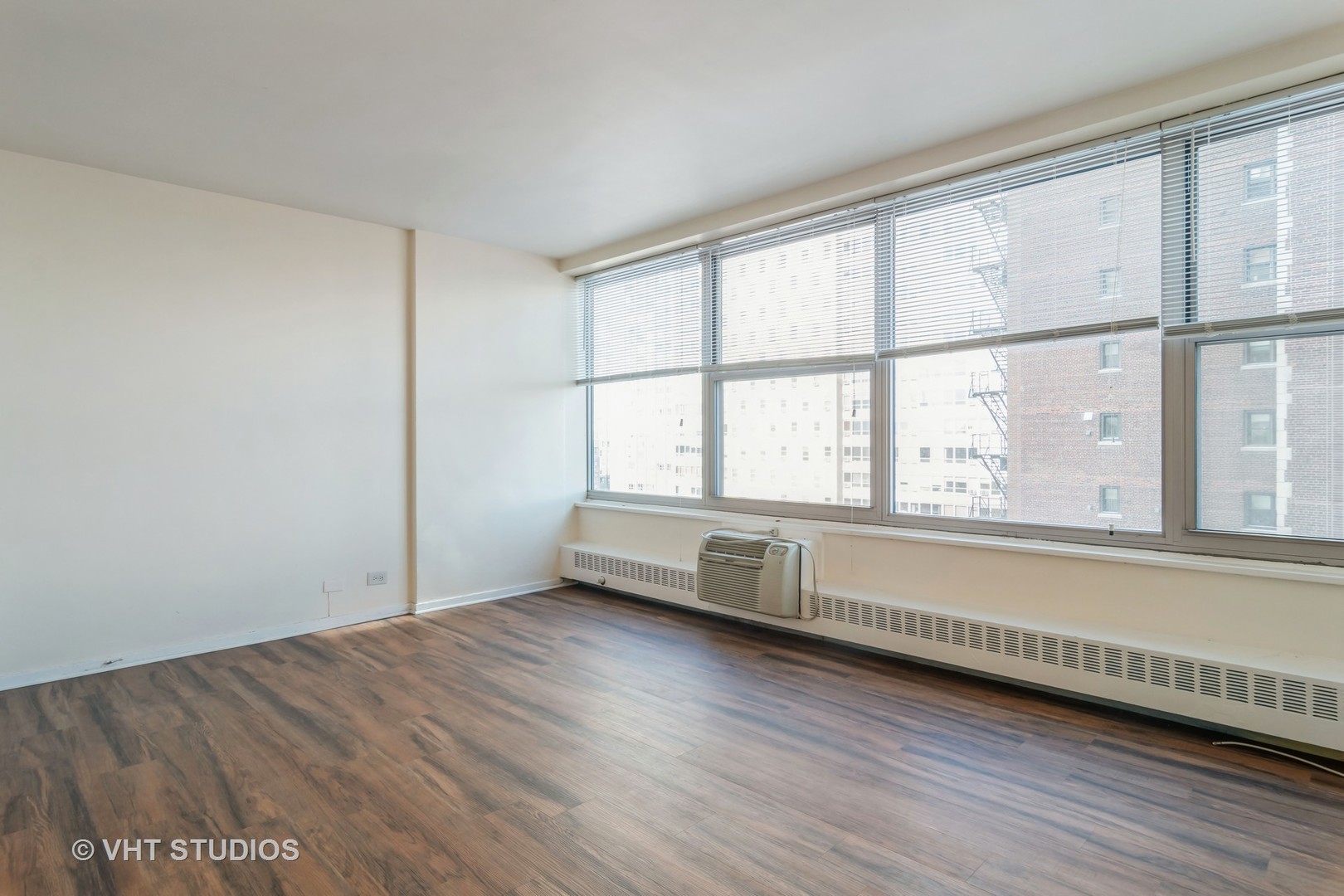3900 North Lake Shore Drive, Unit 9J Chicago, IL 60613 - Photo 9 of 18 an empty room with wooden floor and windows