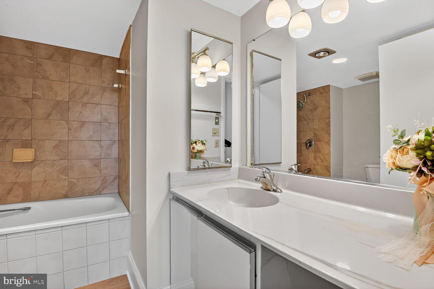 1808 Old Meadow Road, Unit 507 McLean, VA 22102 - Photo 15 of 24 a bathroom with a granite countertop sink a toilet a mirror and shower