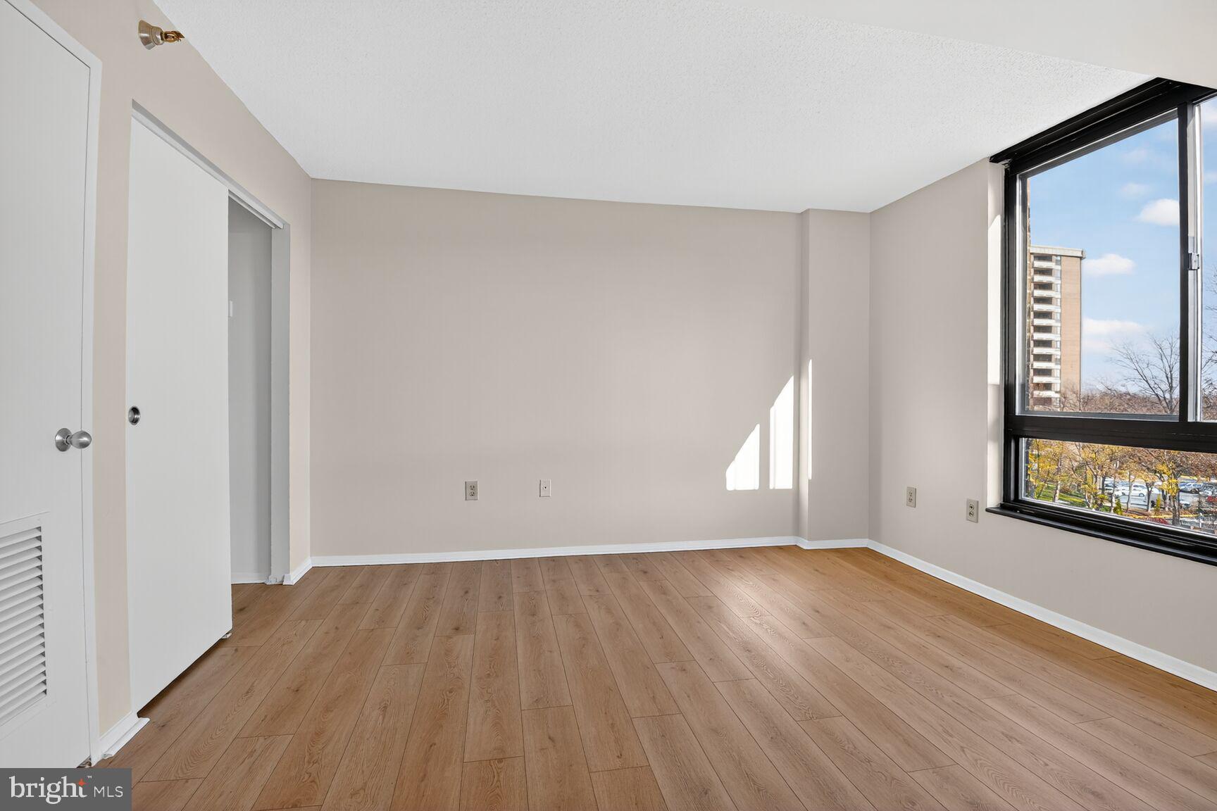 1808 Old Meadow Road, Unit 507 McLean, VA 22102 - Photo 10 of 24 a view of an empty room with wooden floor and a window