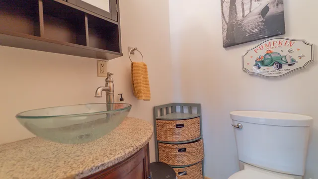 a bathroom with a granite countertop toilet and a sink
