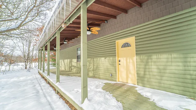 a view of a porch with a table and chairs and floor to ceiling window