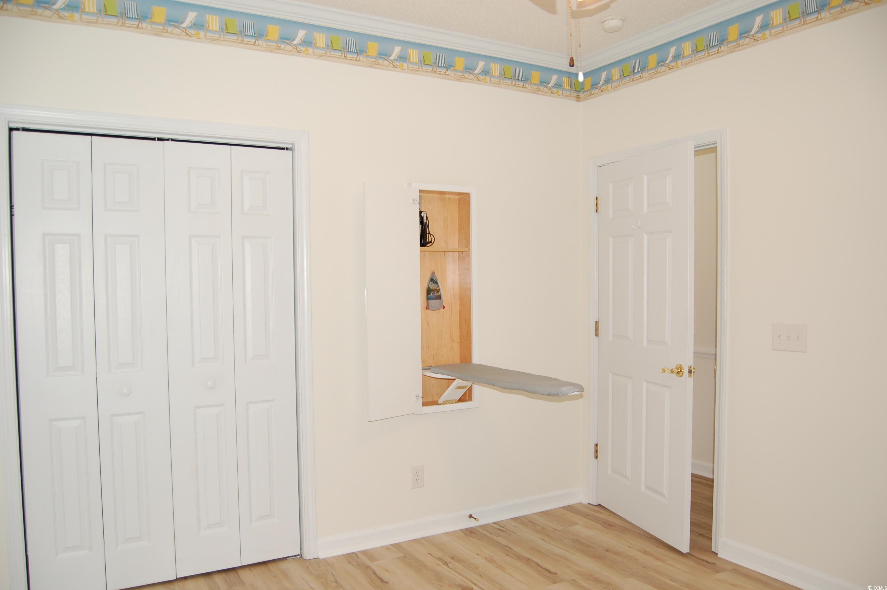 1537 Lanterns Rest Road, Unit 203 Myrtle Beach, SC 29579 - Photo 11 of 35 Unfurnished bedroom featuring light wood-type flooring, built-in ironing board and a closet