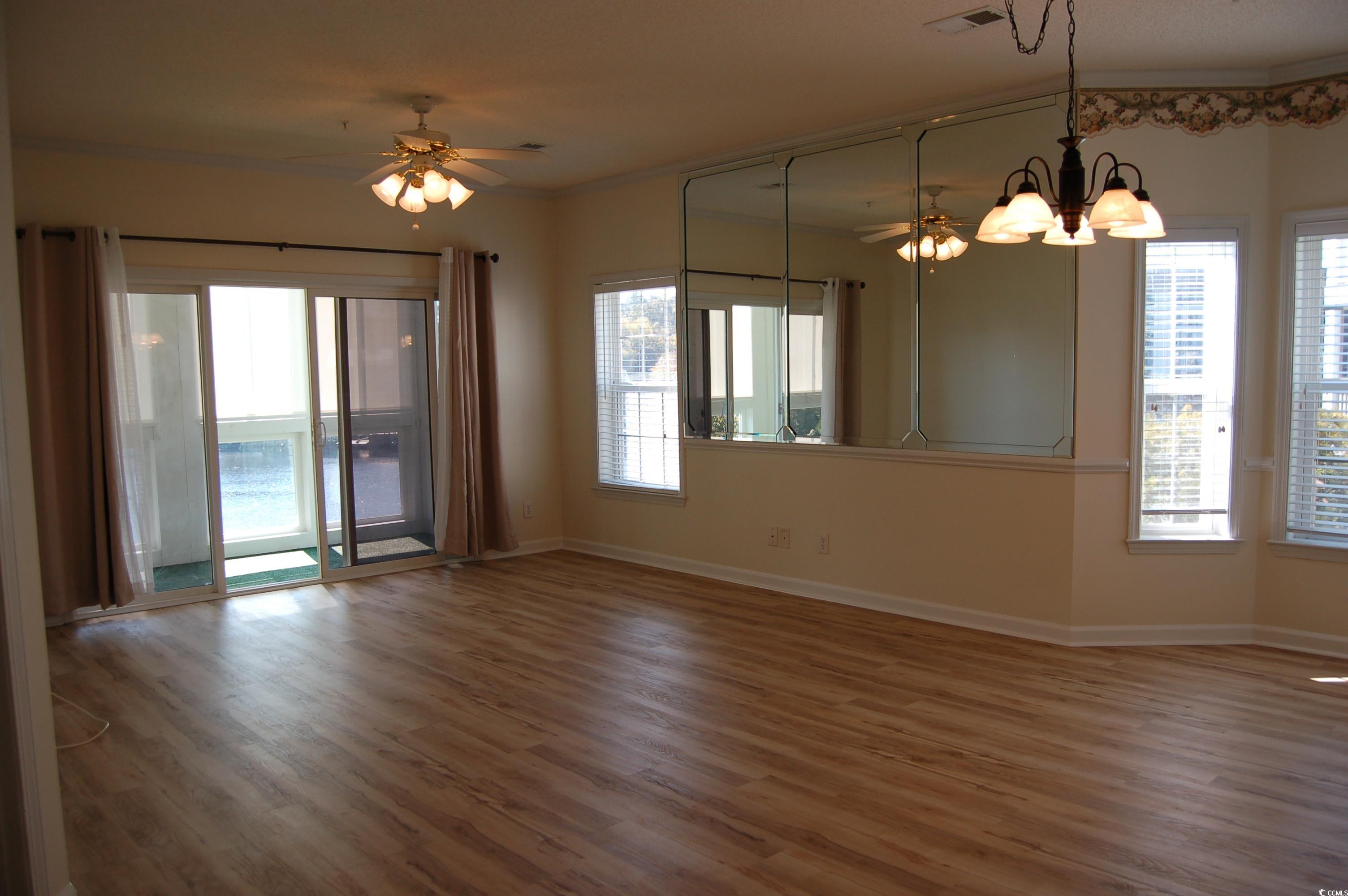 1537 Lanterns Rest Road, Unit 203 Myrtle Beach, SC 29579 - Photo 17 of 35 Spare room featuring a ceiling fan, wood finished floors, crown molding, and a chandelier