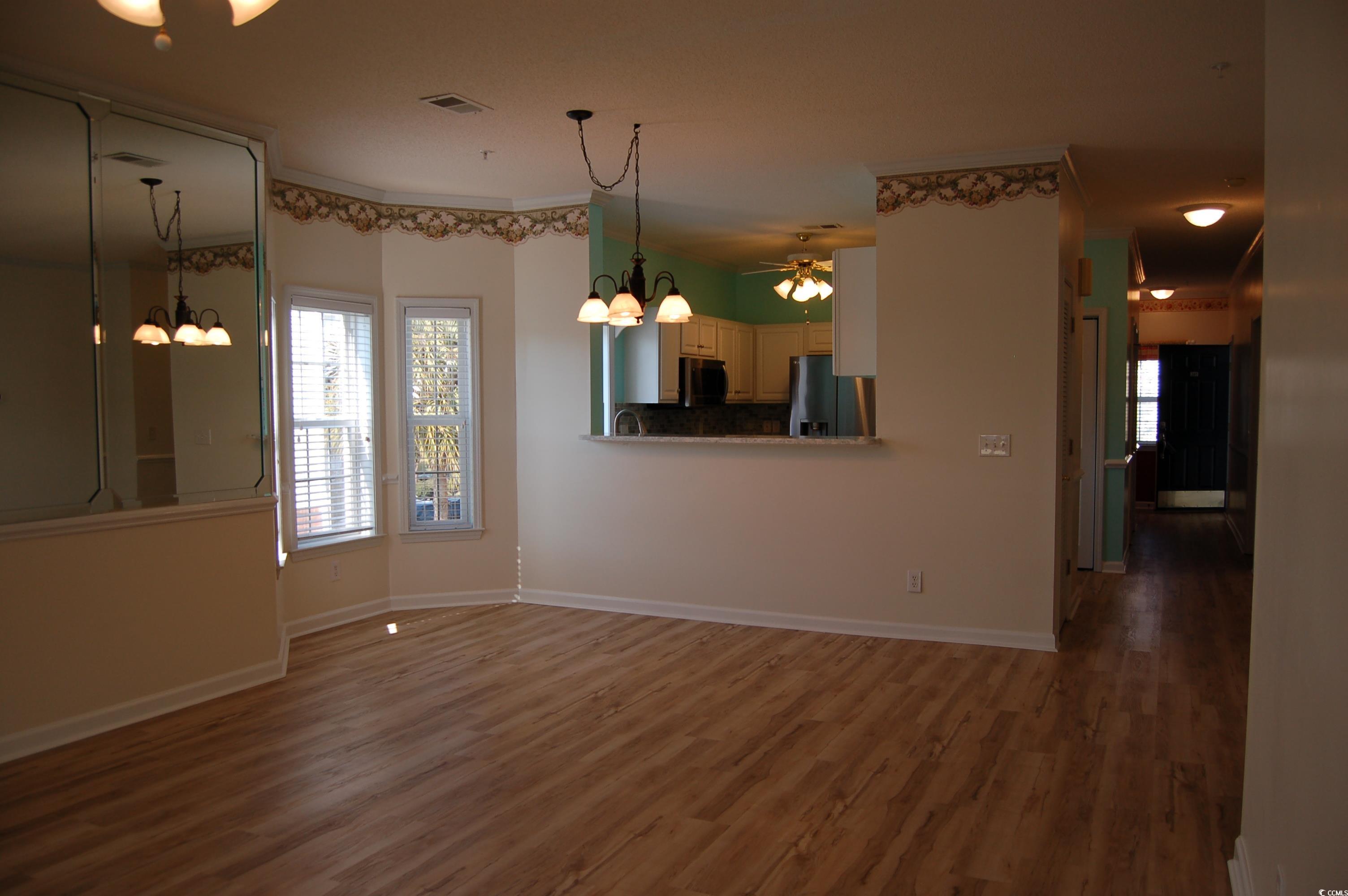 1537 Lanterns Rest Road, Unit 203 Myrtle Beach, SC 29579 - Photo 19 of 35 Unfurnished dining area featuring a chandelier and wood finished floors