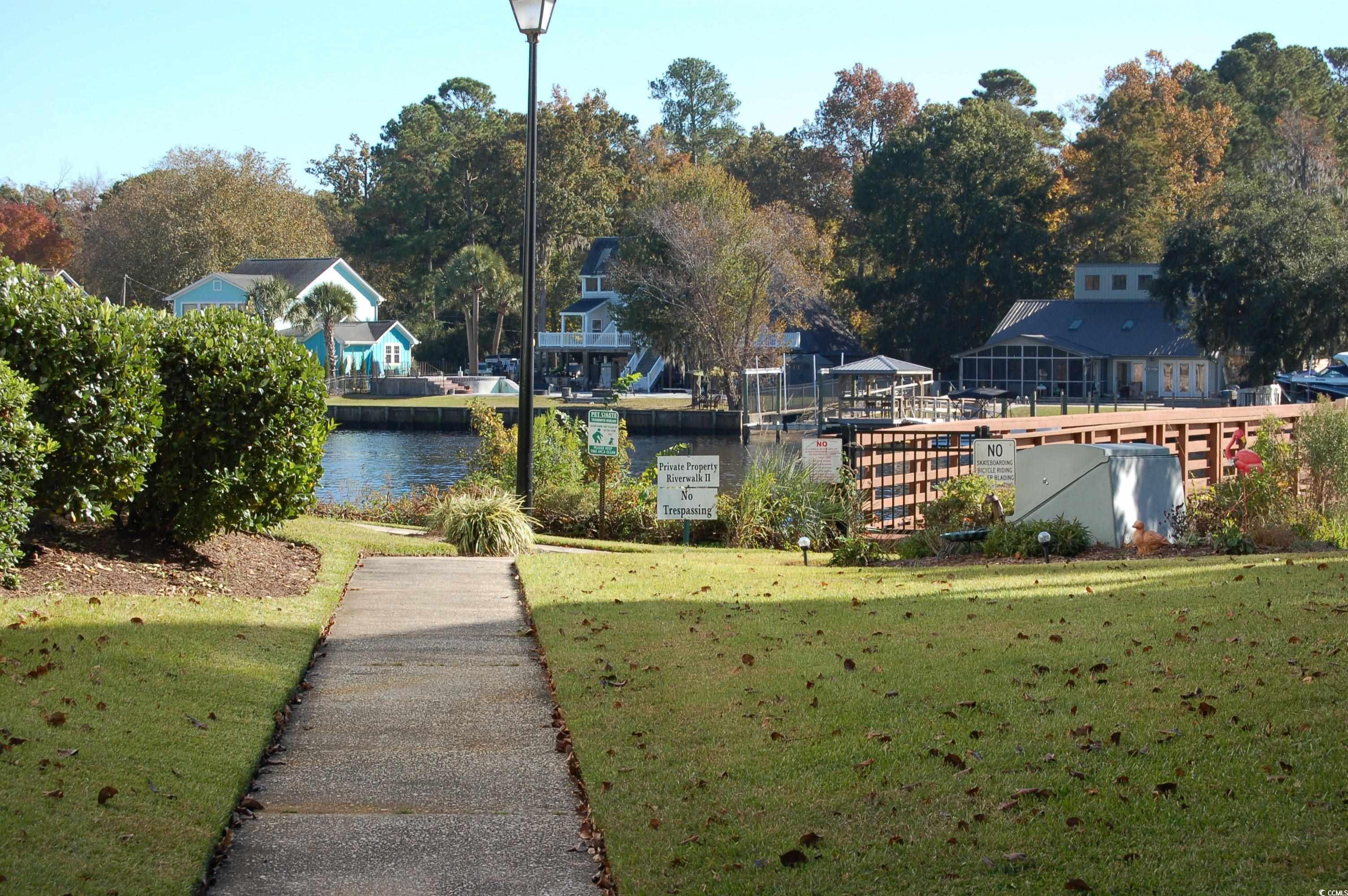 1537 Lanterns Rest Road, Unit 203 Myrtle Beach, SC 29579 - Photo 27 of 35 View of green lawn featuring a water view and view of scattered trees