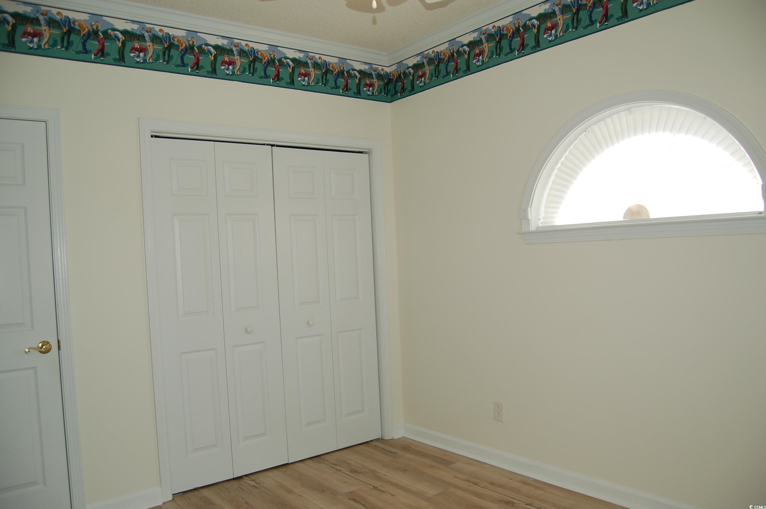 1537 Lanterns Rest Road, Unit 203 Myrtle Beach, SC 29579 - Photo 5 of 35 Unfurnished bedroom with light wood-style floors, a closet, and crown molding