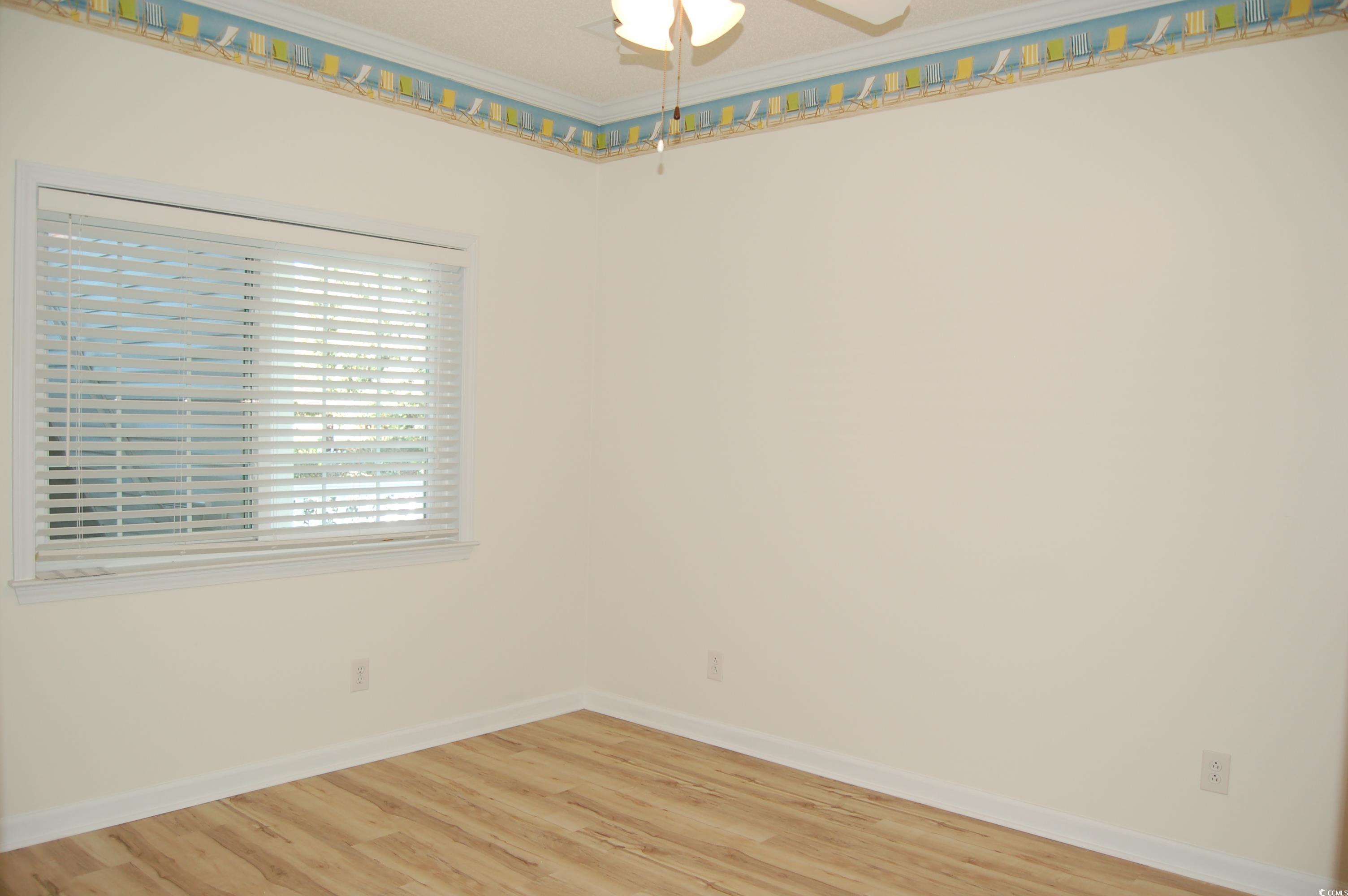1537 Lanterns Rest Road, Unit 203 Myrtle Beach, SC 29579 - Photo 9 of 35 Spare room with crown molding, light wood-type flooring, and ceiling fan