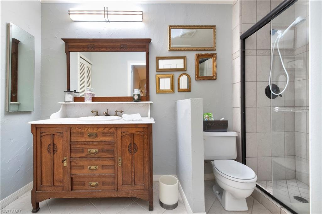5340 Tamarind Ridge Drive Naples, FL 34119 - Photo 13 of 32 a bathroom with a double vanity sink toilet and shower