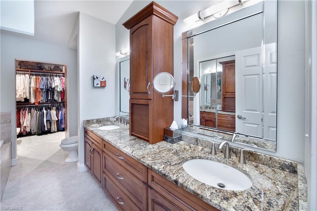 5340 Tamarind Ridge Drive Naples, FL 34119 - Photo 22 of 32 a bathroom with a granite countertop sink a mirror and shower