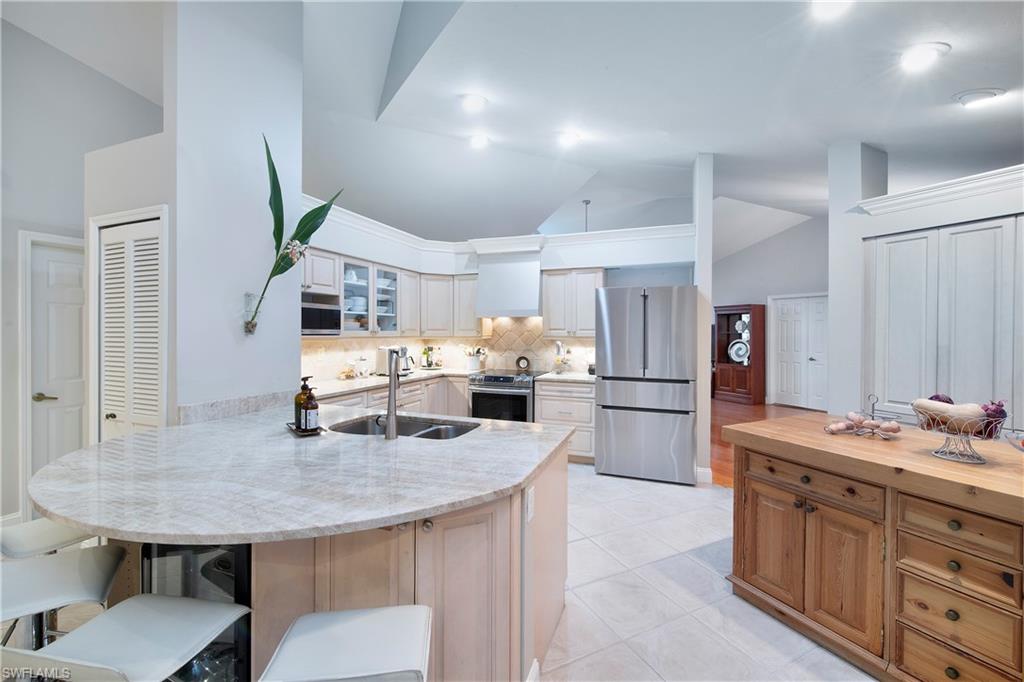 5340 Tamarind Ridge Drive Naples, FL 34119 - Photo 4 of 32 a kitchen with a table chairs and refrigerator